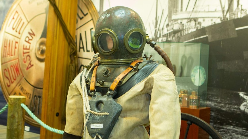 An old fashioned deep-sea diving suit with bell style helmet on display in museum space