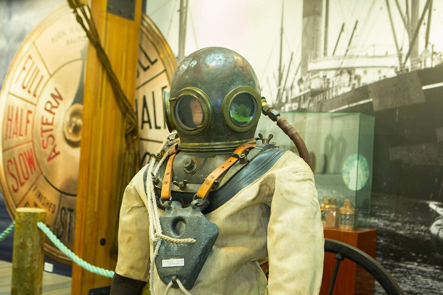 An old fashioned deep-sea diving suit with bell style helmet on display in museum space