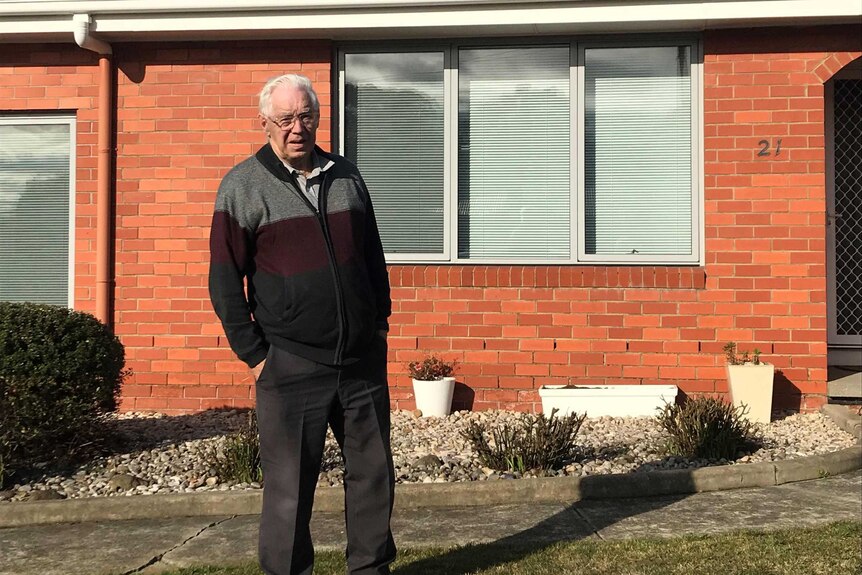 Man stands outside redbrick house