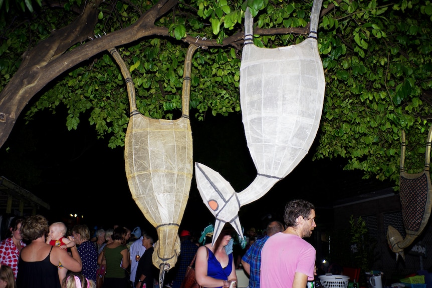 Sculptureof birds in a tree at night made from rubbish