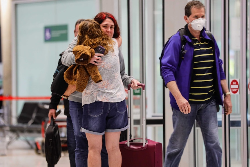 People hug at the Brisbane airport.