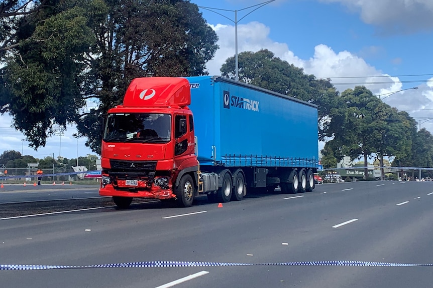 A red and blue Australia Post/ Star Track truck with minor damage to its bumper.