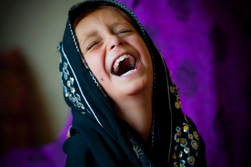 A girl laughs in an isolated Afghan village