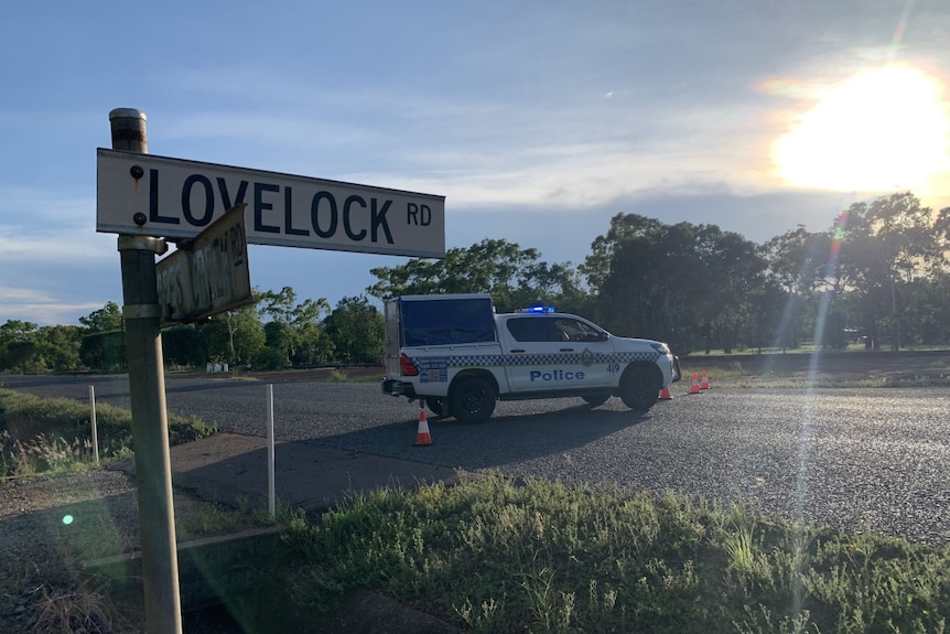 A police car is parked across a road. A street sign in the foreground reads "lovelock road"