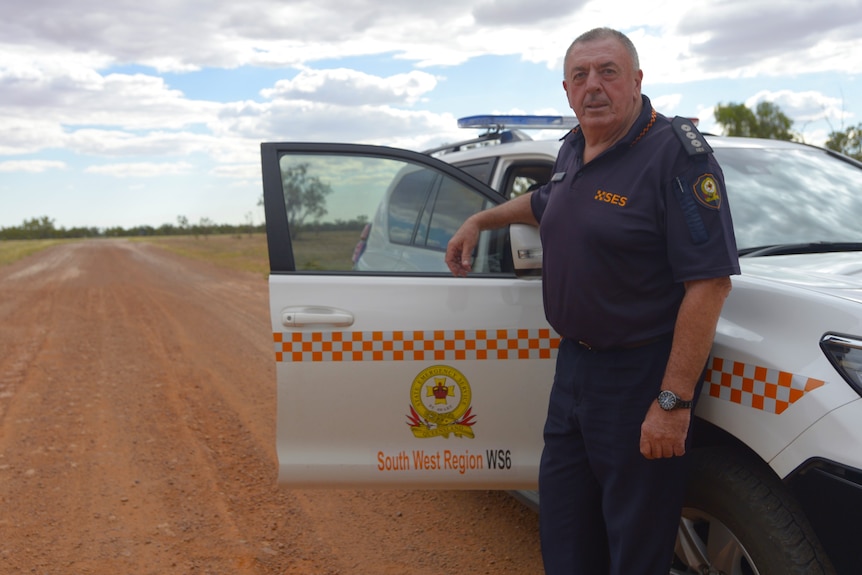 State Emergency Service far west area controller John Wallace next to his car on an outback Queensland road.