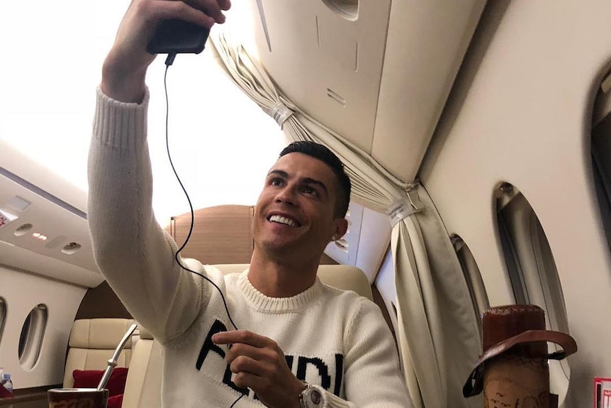 Cristiano Ronaldo sitting in a private plane, taking a photo of himself.
