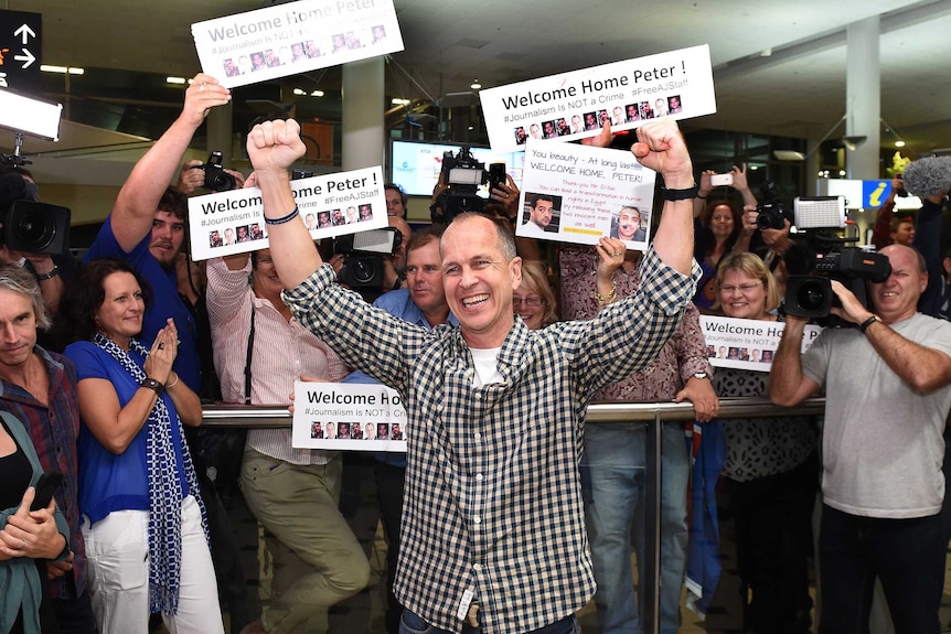 Peter Greste greets supporters at Brisbane airport