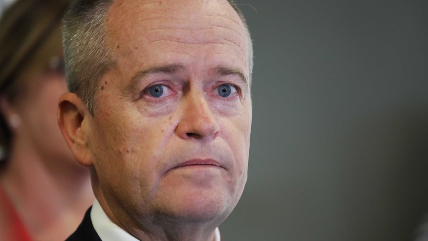 Bill Shorten's eyes are wet as he holds back tears at a press conference
