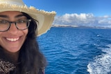 Ridhima grins, taking a selfie on a boat out on the water.