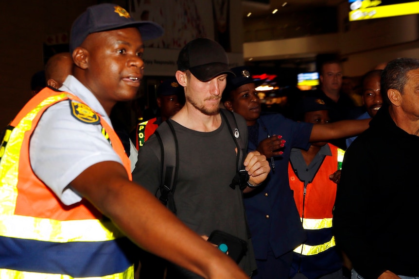 Cameron Bancroft is escorted by police officers