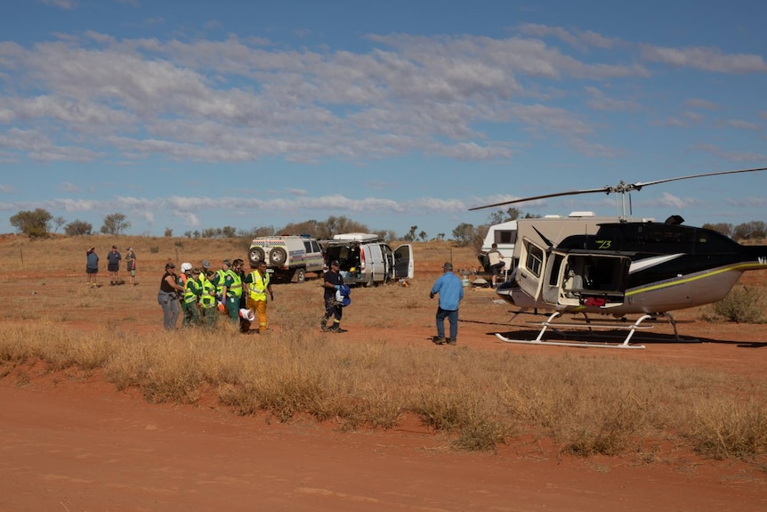 An injured person at the Finke Desert Race being carried to a helicopter.
