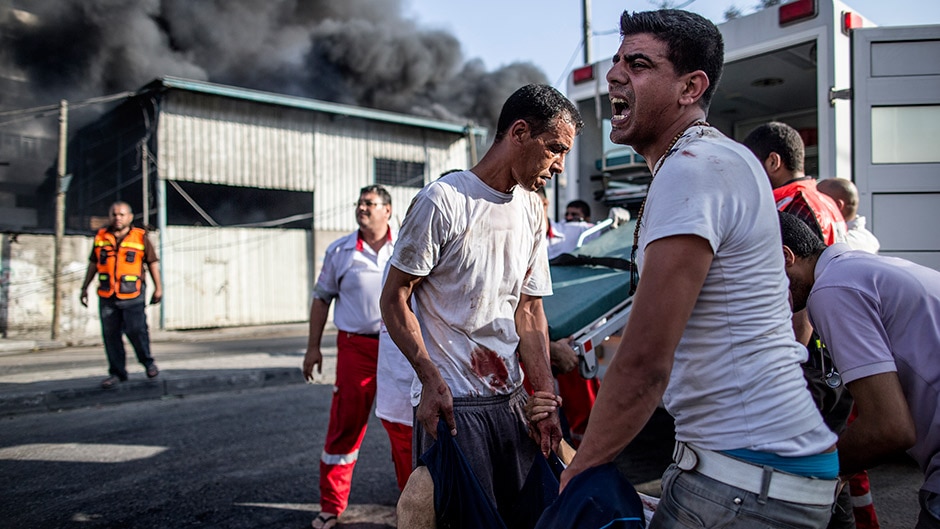 Emergency personnel and civilians evacuate victims of an Israeli air strike on a market place near Gaza City.