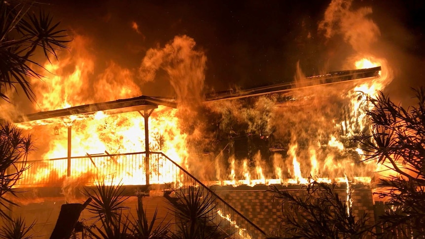 Fire engulfs a home at night.
