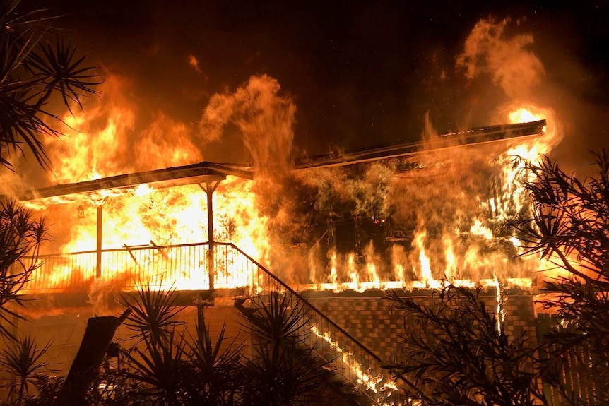Fire engulfs a home at night.