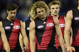 Dyson heppell leads Essendon players off the field after their loss to Western Bulldogs