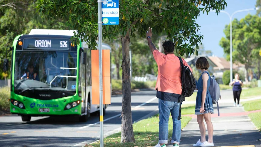 Two people hailing a bus on street