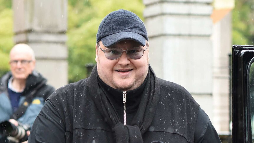 Internet mogul Kim Dotcom stands outside High Court dressed in black