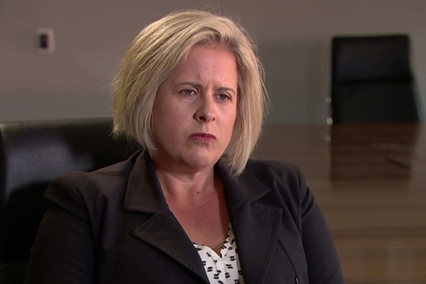 Danita Wawn sitting down wearing a black suit jacket with black and white shirt.