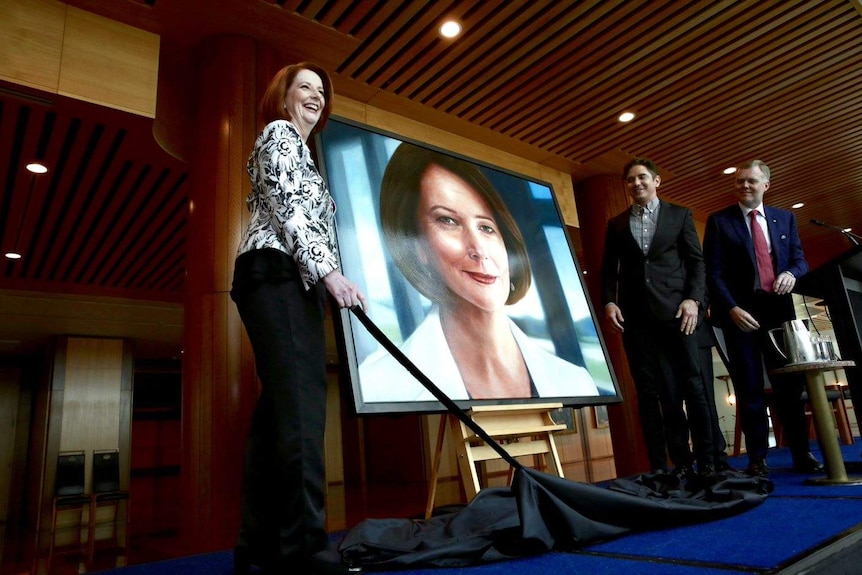 Julia Gillard stands alongside her portrait