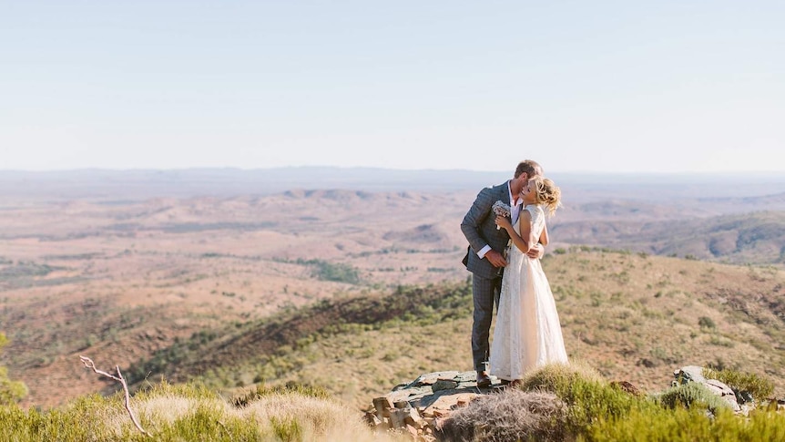 A photo of a bride and groom on a clifftop at a rural property