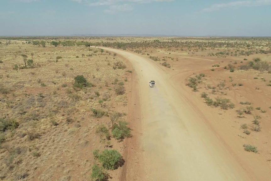 Drone shot of four wheel drive on gravel track in the outback