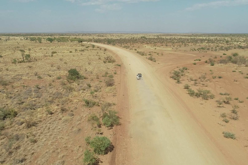 drone shot of four wheel drive on gravel track to Wangkatjungka community