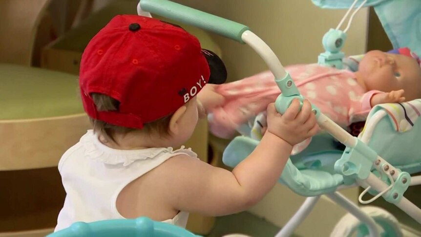 A little child wearing a red hat.
