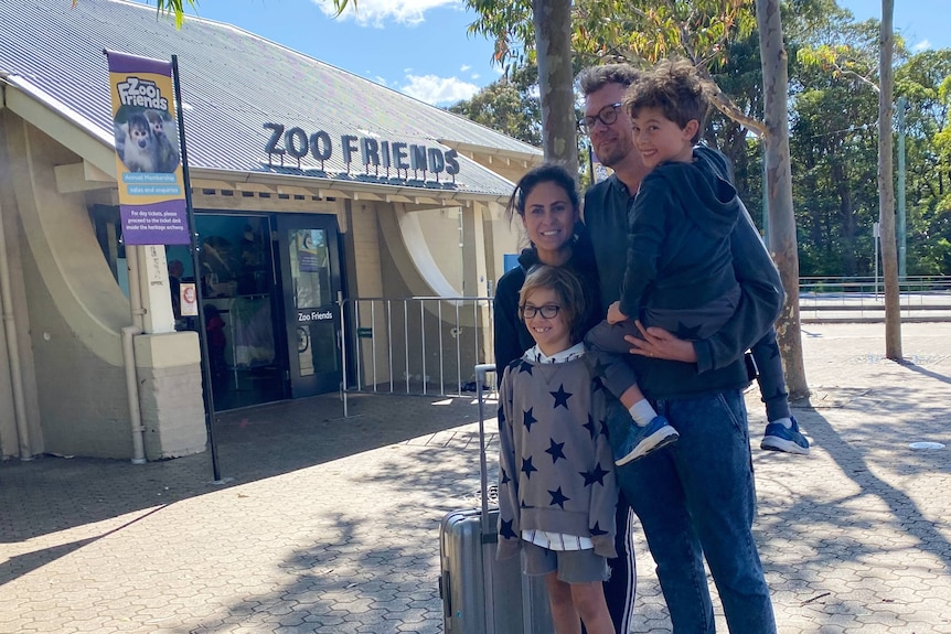 A family stand outside a sign saying zoo friends
