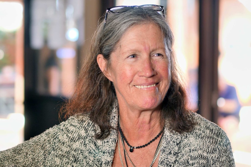 A woman with greying hair smiles.