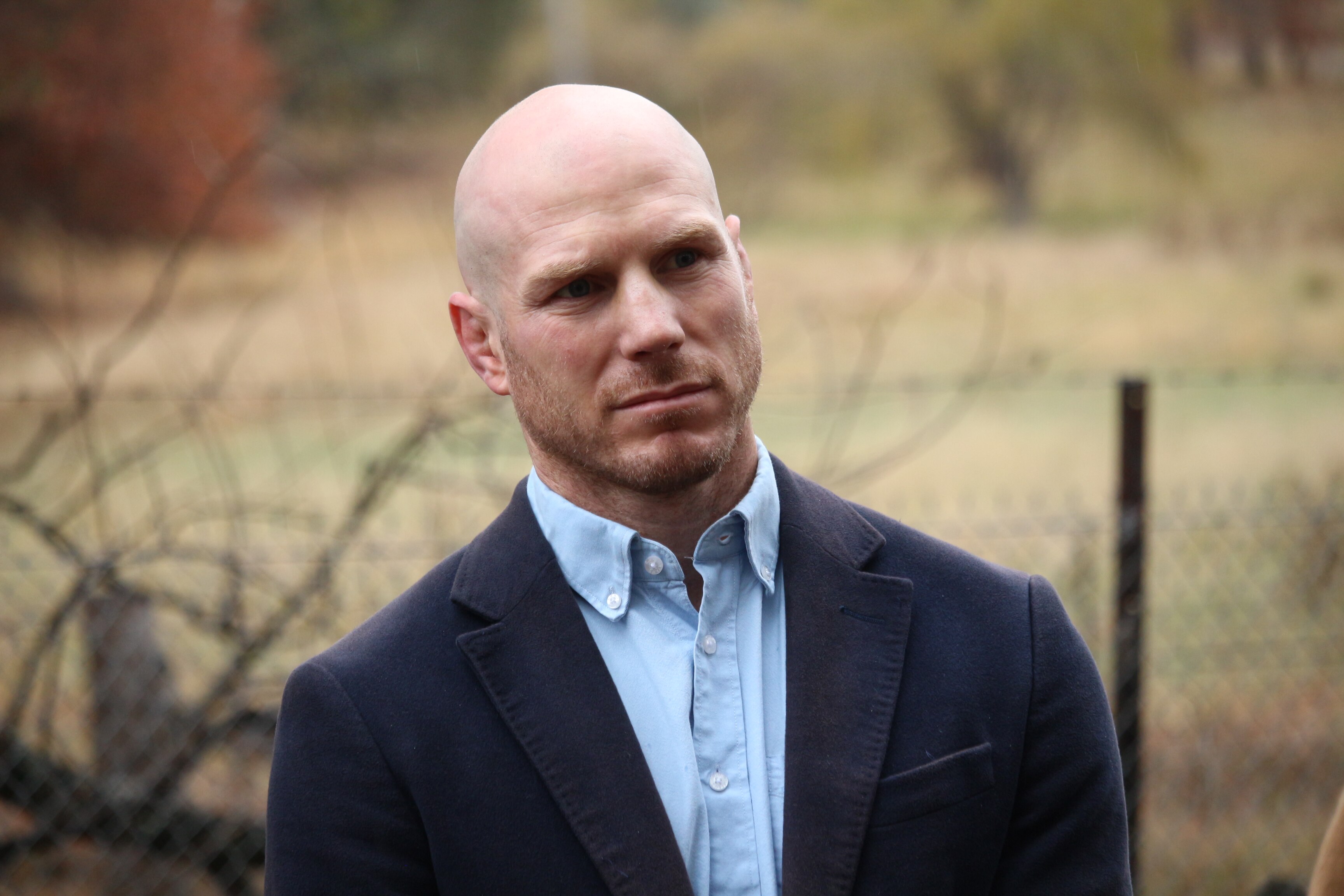 A bald man looking off to the right of the frame