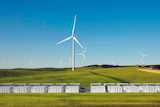 A wind farm located on green hills.