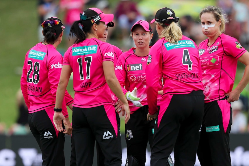 The Sydney Sixers WBBL team look relieved after getting a run out off the last ball.