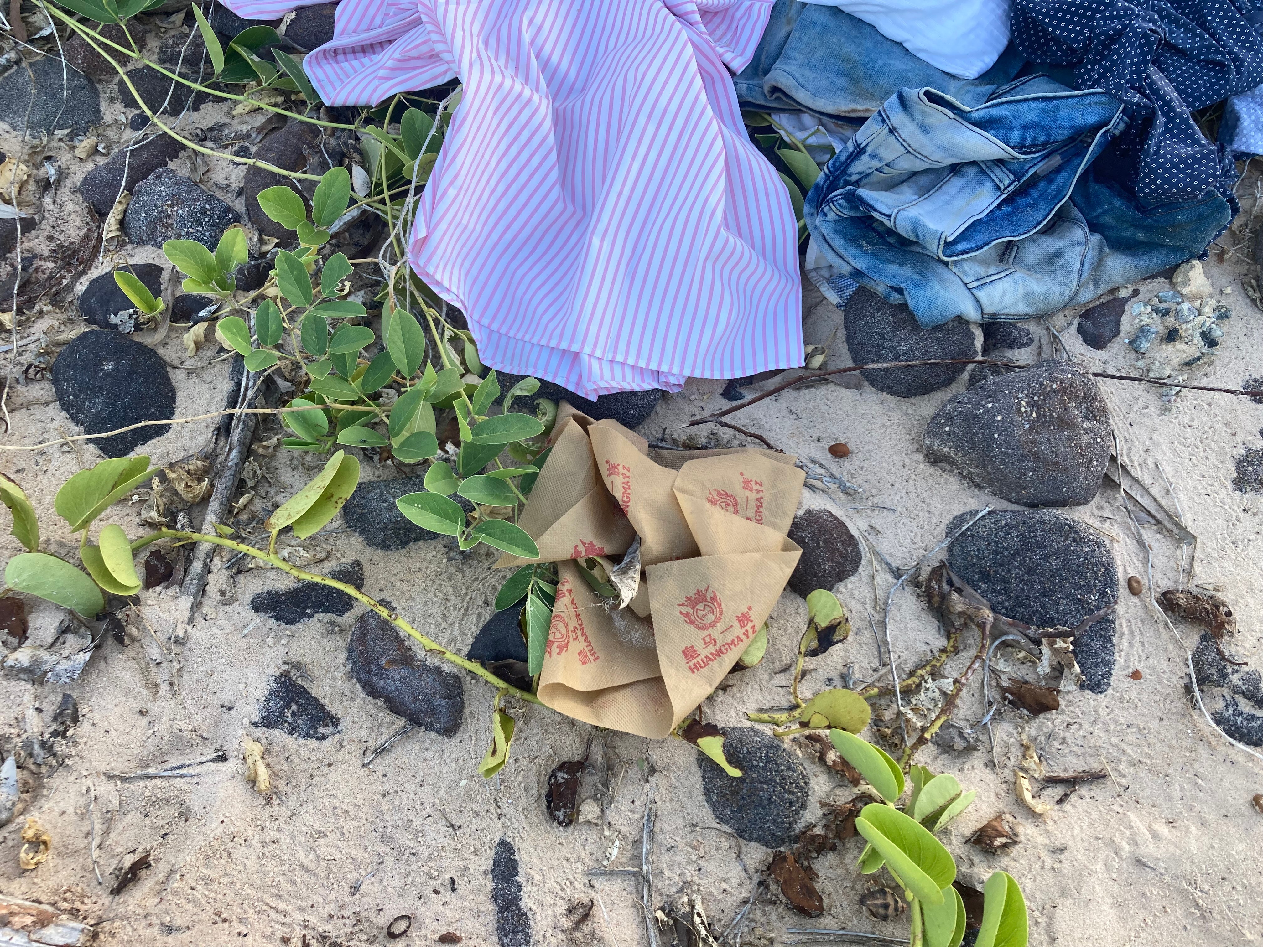 A striped shirt and denim clothing left behind on the shore.