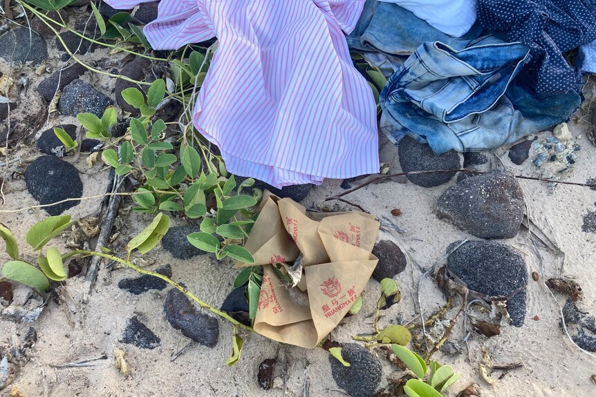 A striped shirt and denim clothing left behind on the shore.