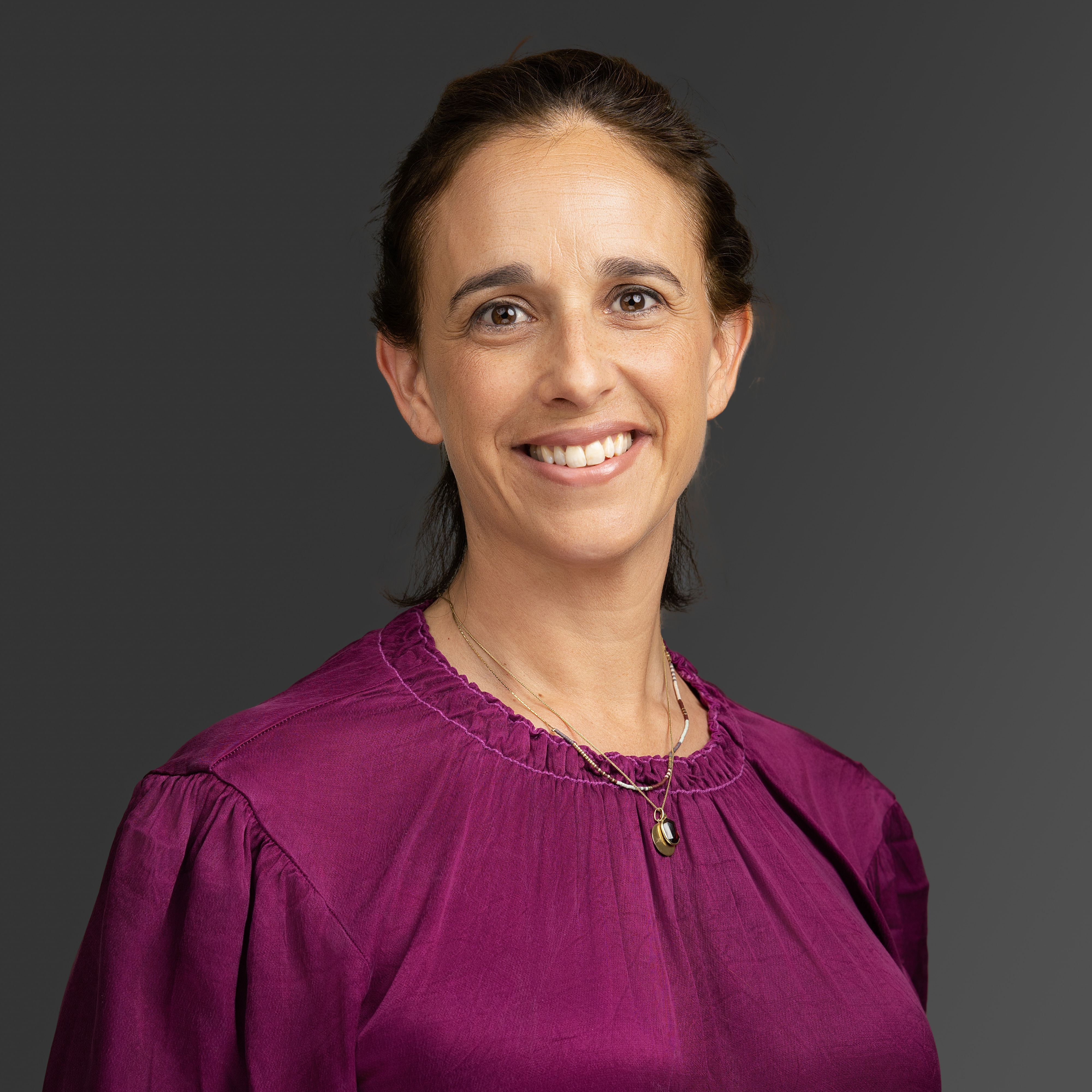 Una mujer sonríe para un retrato profesional.