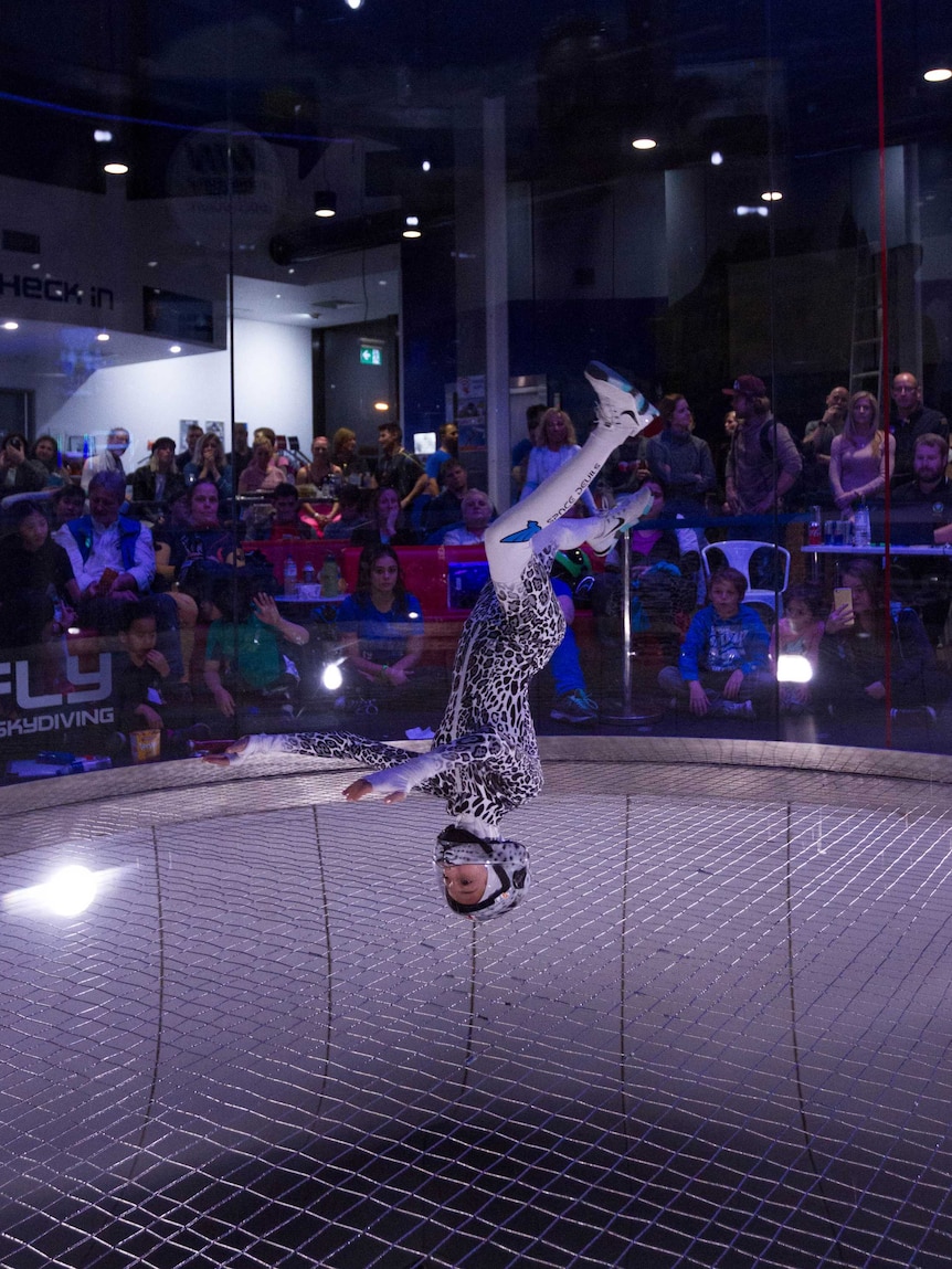 Amy Watson upside down performing indoor skydiving