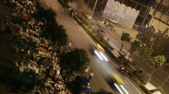 People sleep on the pavement of a street in Chengdu in Sichuan Province