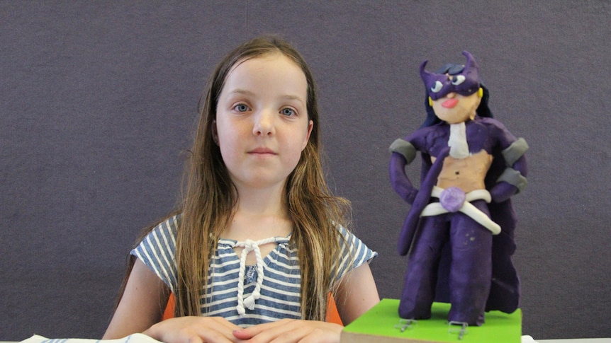 Young artist Ann, 11, with her Catwoman sculpture