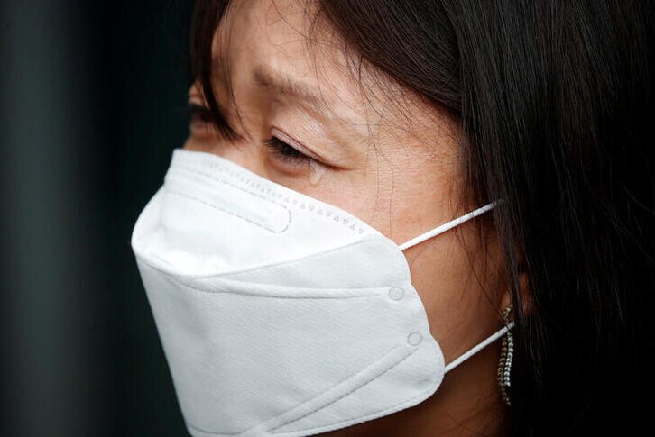 Kara Bos is wearing protective face mask, facing the left with a tear coming down her eye.