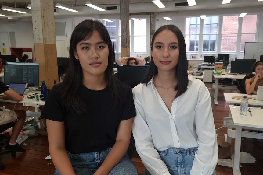 Two young women in a classroom.