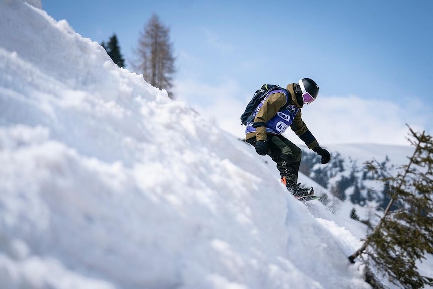 Snowboarder heads down hill