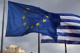 The EU and Greek flags fly in front of the Parthenon on the Acropolis