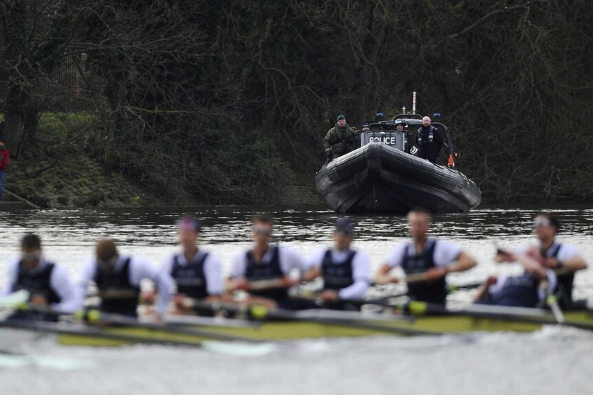 Police and Royal Marines watch over Oxford University boat crew in annual race