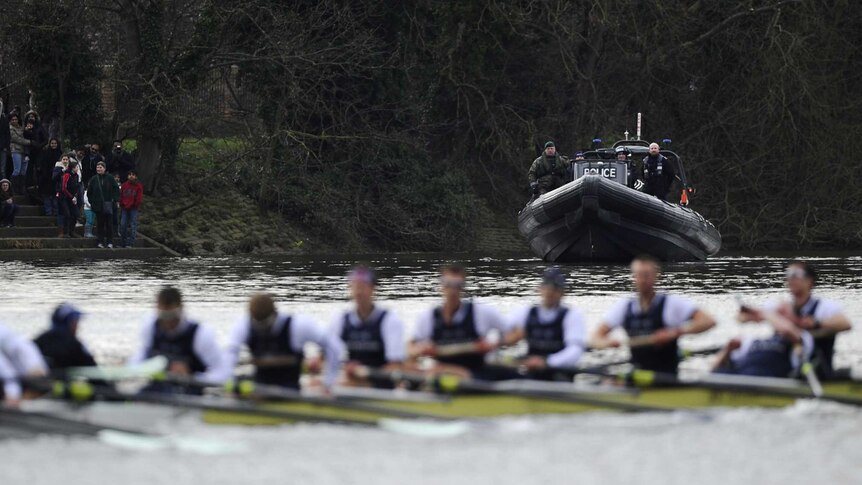 Police and Royal Marines watch over Oxford University boat crew in annual race
