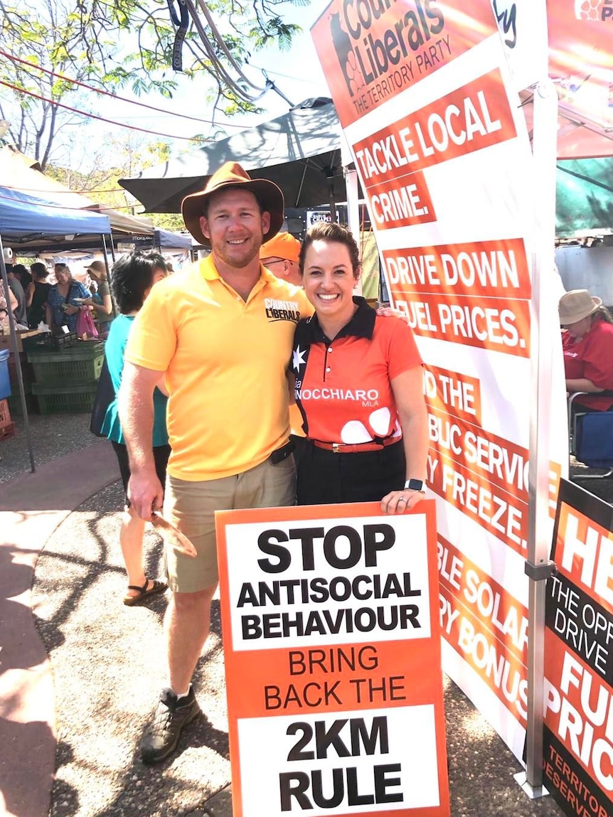 Ben Hosking and Lia Finocchiaro stand together behind a corflute at the Parap markets.