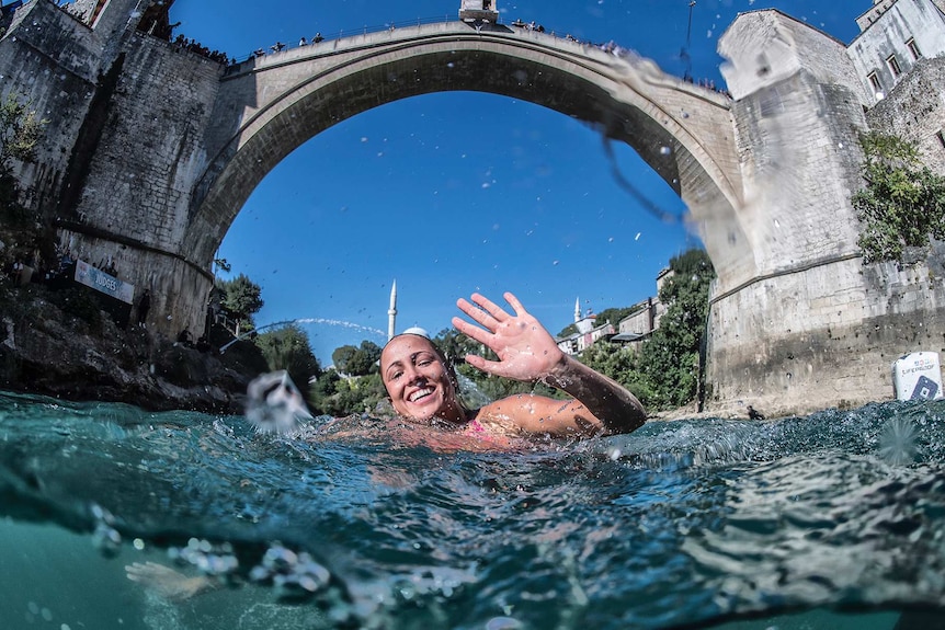 Helena Merten waves to the camera after a 21.5-metre dive off Stari Most Bridge in Mostar, Bosnia and Herzegovina.