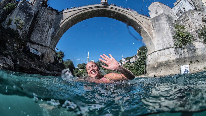 Helena Merten waves to the camera after a 21.5-metre dive off Stari Most Bridge in Mostar, Bosnia and Herzegovina.