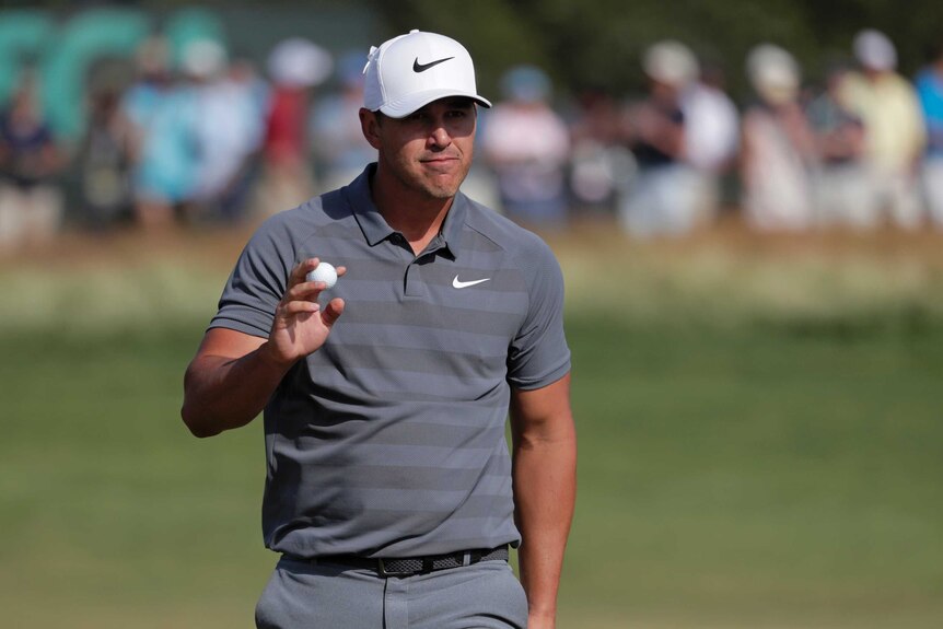 Brooks Koepka reacts after putting on the 12th green