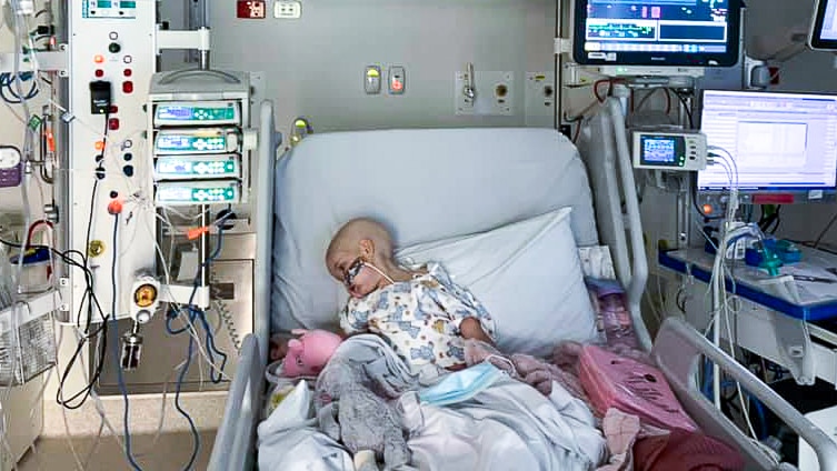 a young girl lies in a hospital bed