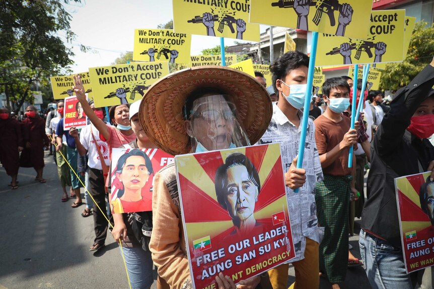 A large crowd of protesters carrying signs reading "we don't accept military coup" and "free out leader Aung San Suu Kyi".